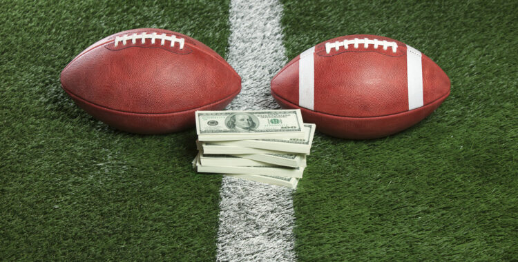 Footballs with a pile of money on the line
